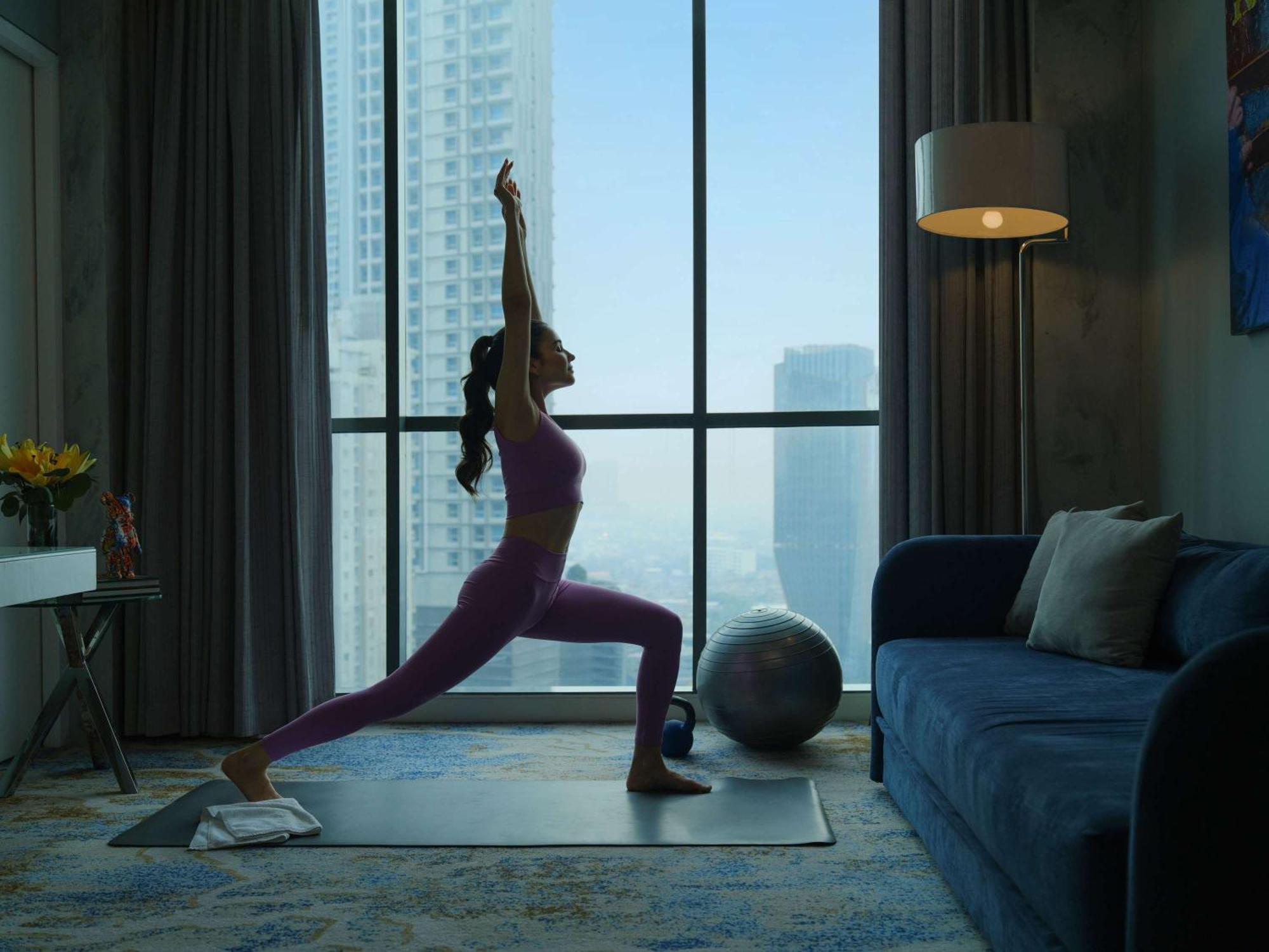 Pullman Jakarta Central Park Dış mekan fotoğraf A woman practicing yoga at home